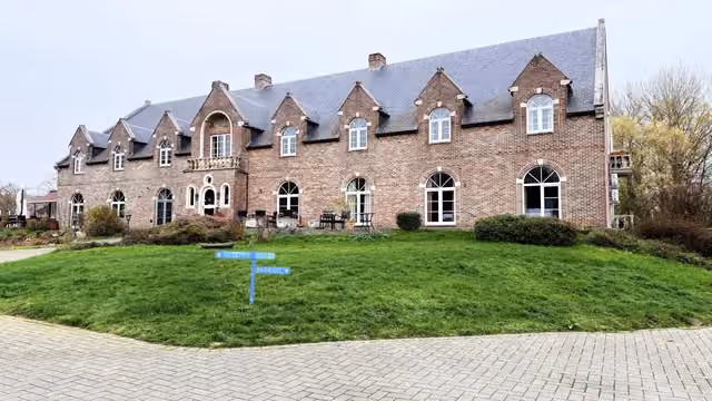 De oprit met de wegwijzers naar receptie en parking