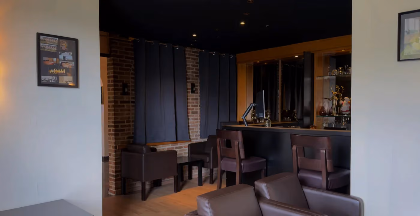 De lounge met leren zetels en de bar