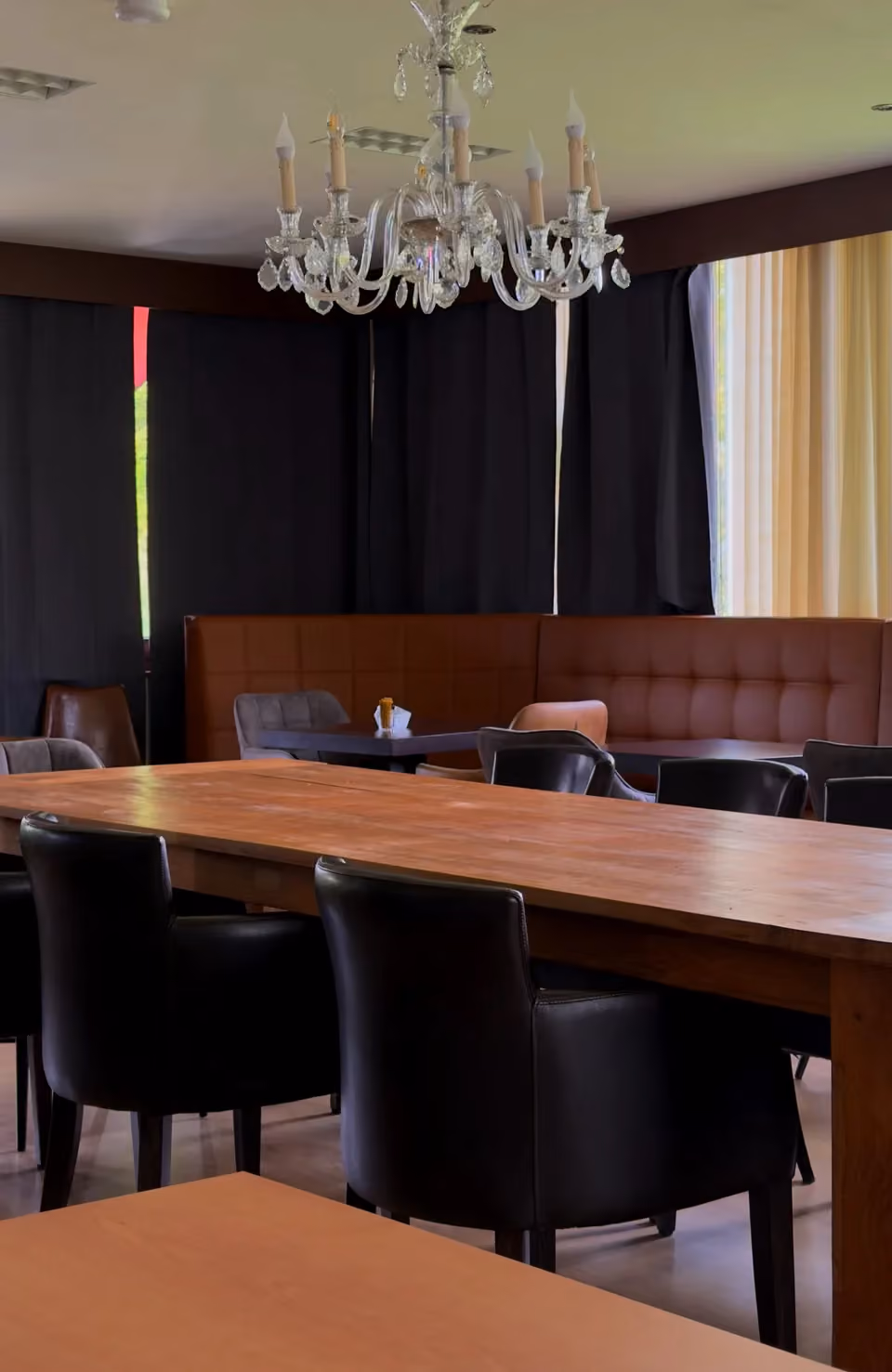 De zaal met kristallen luster en de lange houten tafel